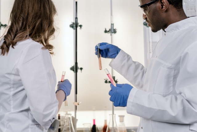 Two scientists examining test tubes