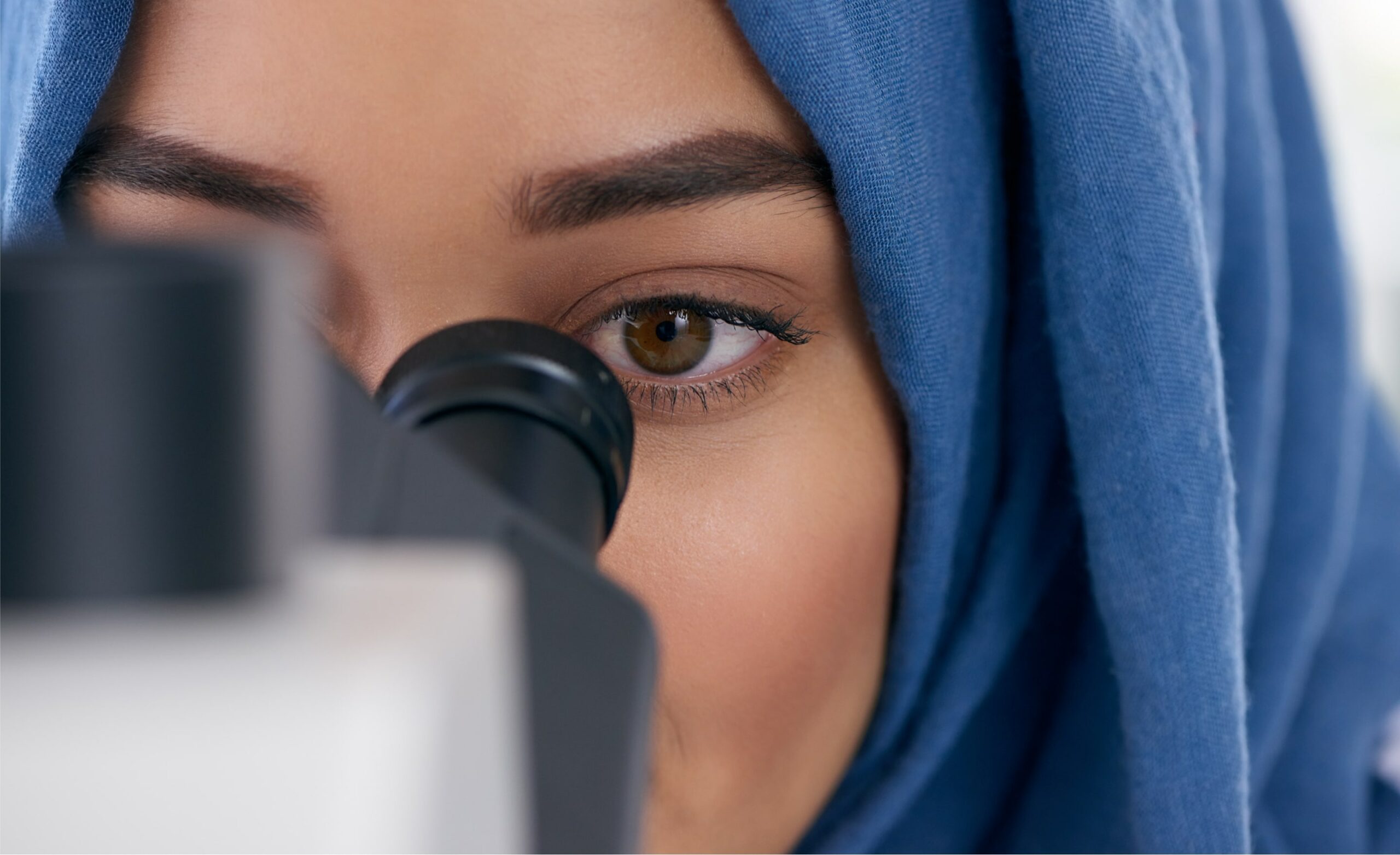 A young scientist using a microscope in a lab