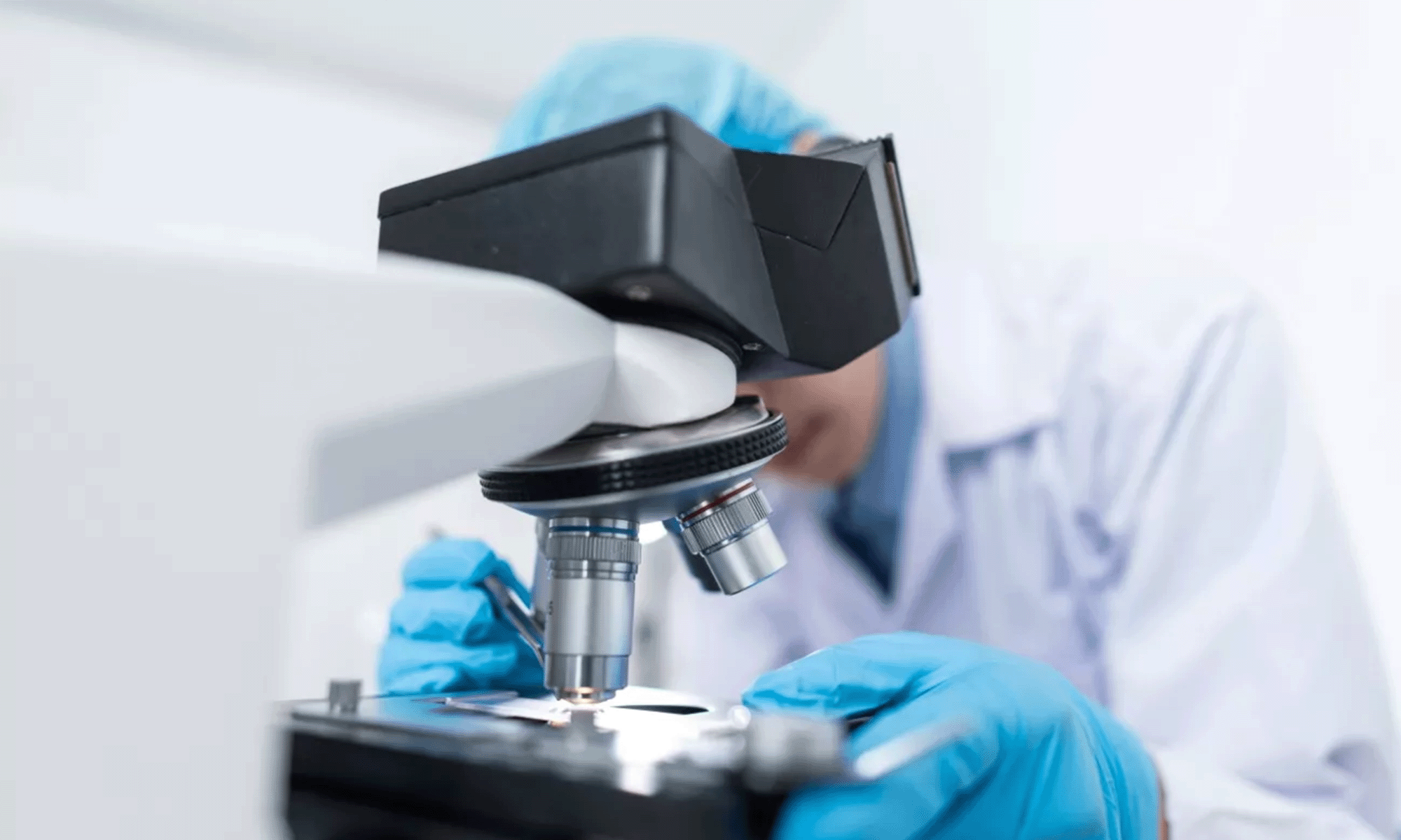 A scientist peers into a microscope